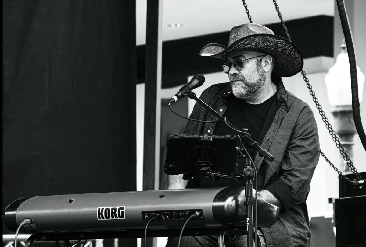 Nic Whitworth singing at the keyboard at a live event